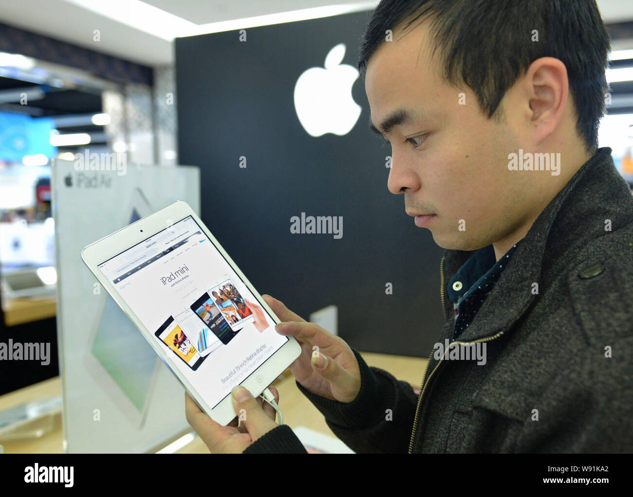 Un client essaie l'un Apple iPad Mini avec écran Retina une dans un magasin du centre-ville de Hangzhou, province de Zhejiang, Chine de l'Est 12 novembre 2013. Apple en Banque D'Images