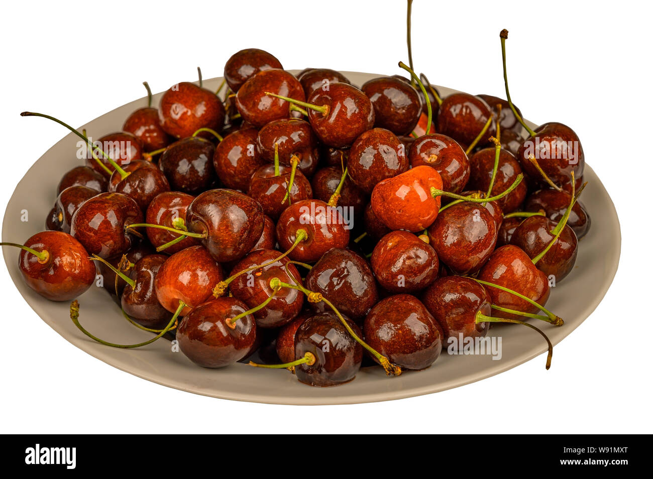 Les cerises dans un plat sur la table. Isoler sur fond blanc Banque D'Images