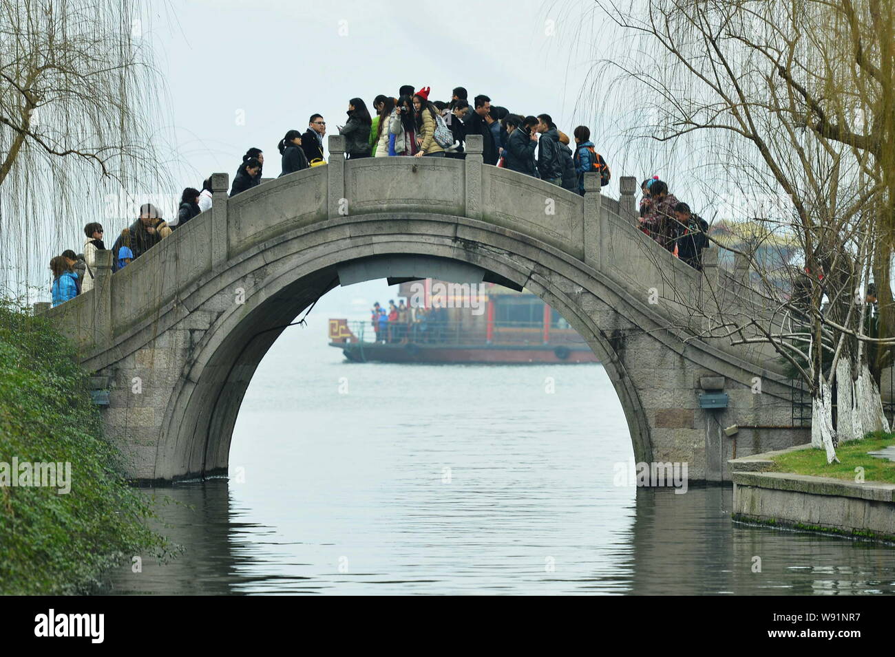 --FILE--visiteurs à pied traverser un pont près de la ville de Hangzhou West Lake, East Chines dans la province du Zhejiang, 13 février 2013. Une ville en Chine est offre stage Banque D'Images