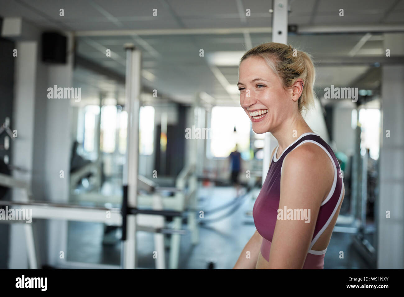 Jeune femme rire dans la salle de sport s'amuser tout en exerçant Banque D'Images