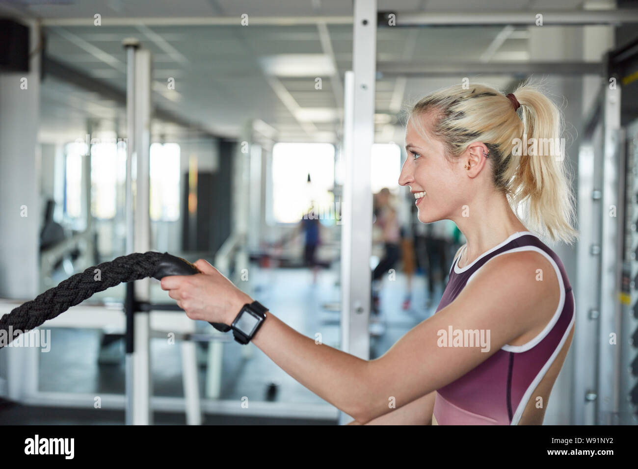 Jeune femme au centre de remise en forme en guerre pour la formation de corde de force et d'endurance Banque D'Images