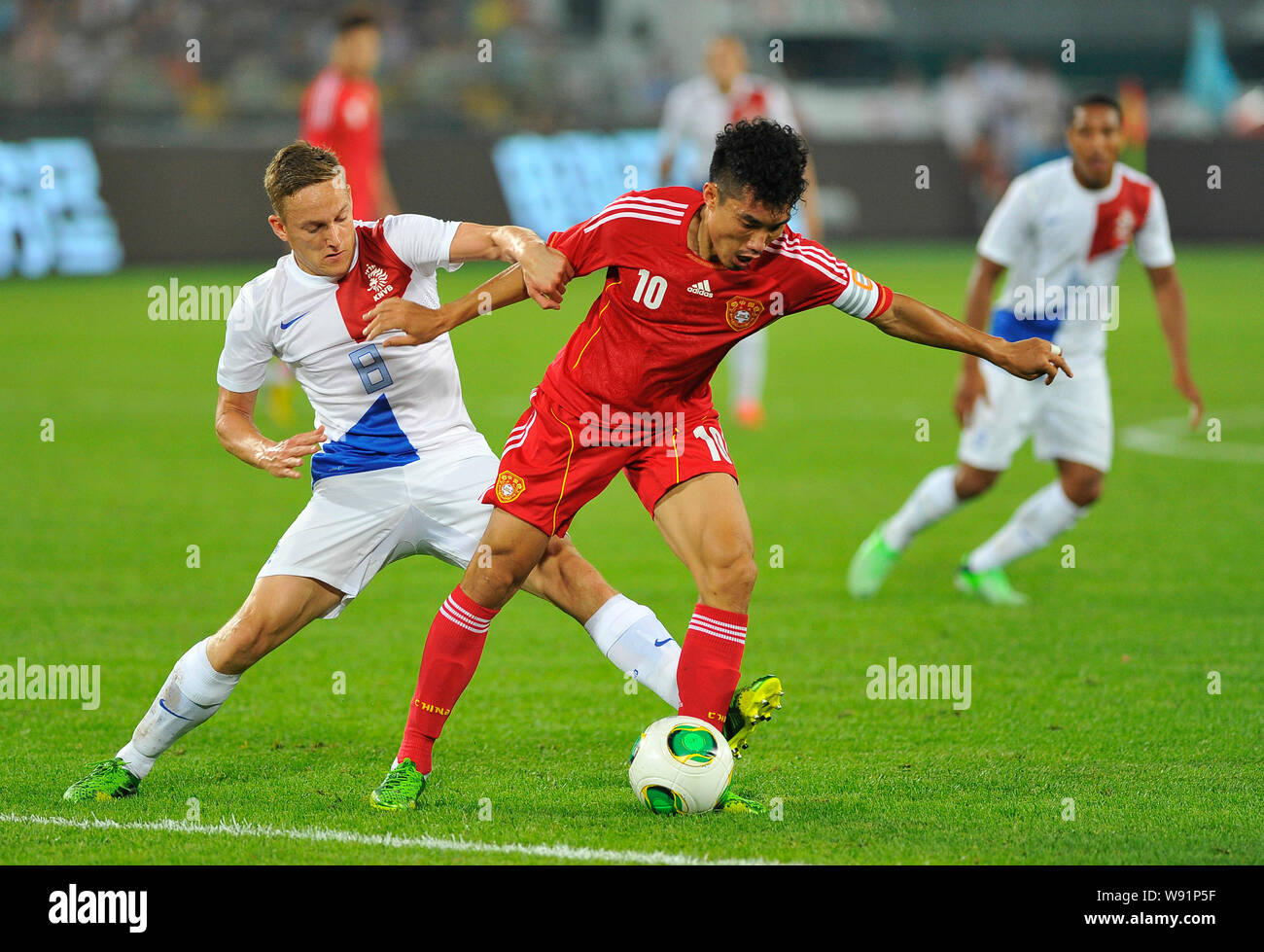 Zheng Zhi de Chine, droit, défis Jens Toornstra des Pays-Bas lors d'un match de football amical à Beijing, Chine, 11 juin 2013. Robin van P Banque D'Images