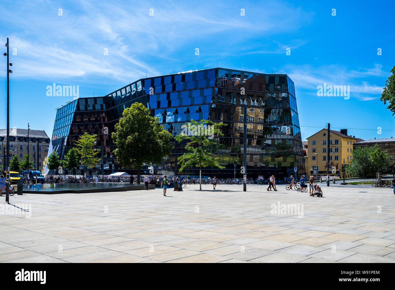 Freiburg im Breisgau, Allemagne, le 8 août 2019, d'innombrables vélos et personnes passant par la façade moderne en verre de bâtiment vu depuis la bibliothèque de l'université Banque D'Images