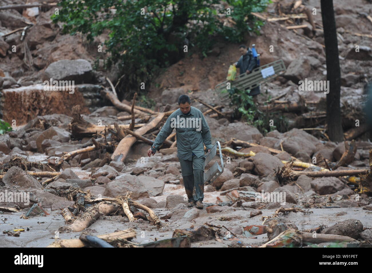 Les sauveteurs chinois passent devant les débris d'un glissement de terrain et les inondations causées par de fortes pluies dans le sud-ouest de la ville de Dujiangyan, dans la province du Sichuan, Chine, 11 Juillet 20 Banque D'Images