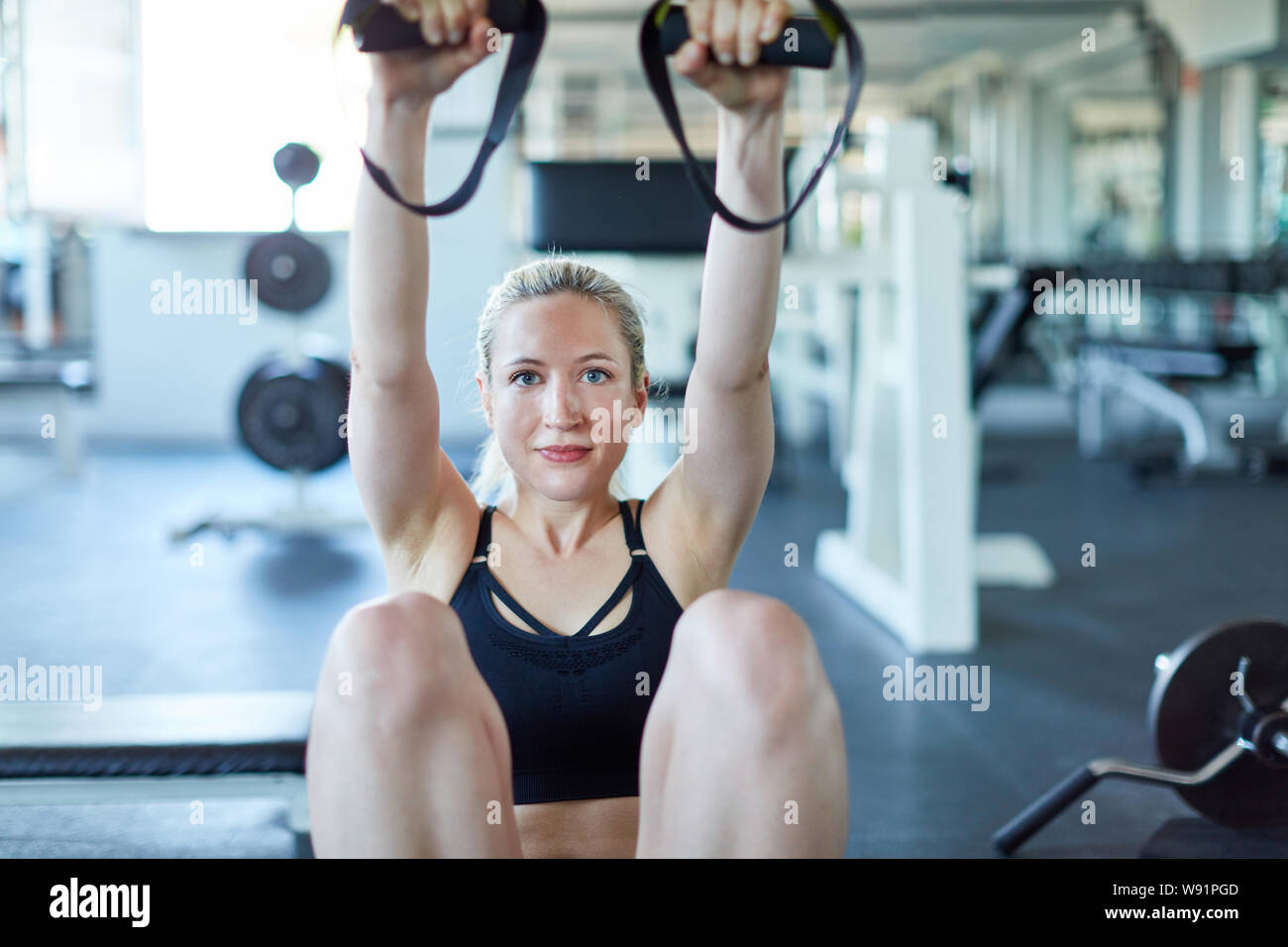 Jeune femme dans une salle de sport à dos en santé formation avec sling trainer Banque D'Images