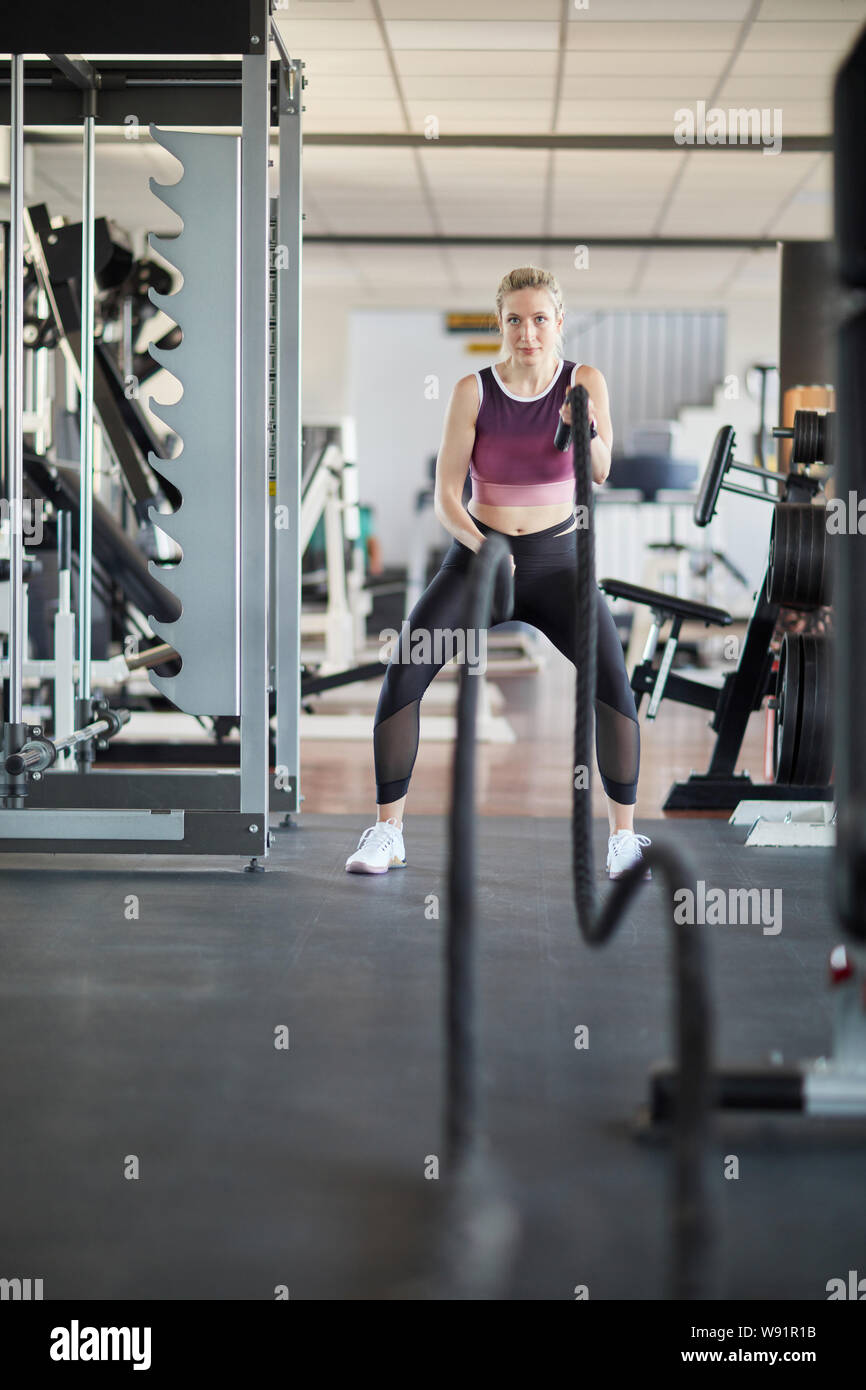 Jeune femme dans la salle de remise en forme de l'endurance avec force la bataille d'acier Banque D'Images