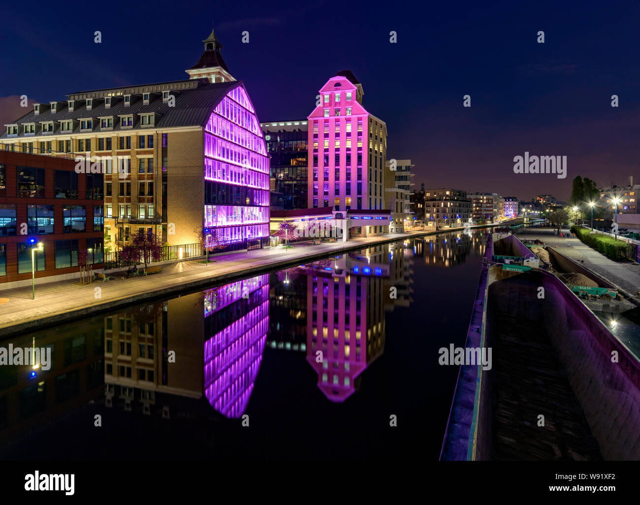 PANTIN, FRANCE - 8 avril 2019 : Pantin vieux moulins à farine par nuit ('Grands Moulins de pantin" en français) réfléchir à canal de l'Ourcq. Banque D'Images