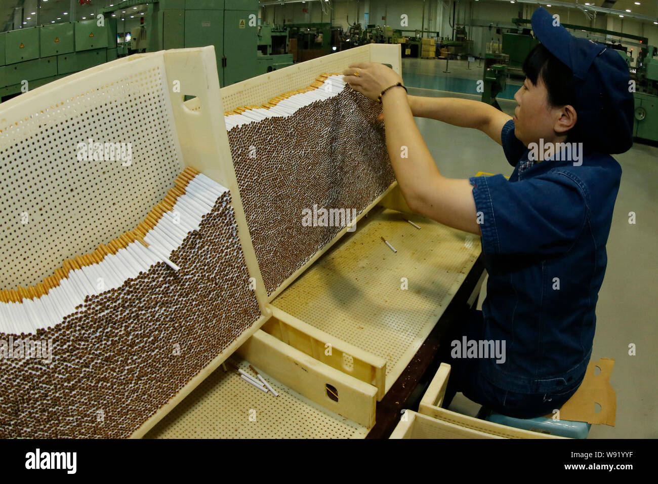 FILE--un travailleur contrle des cigarettes fabriques  une ligne  d'assemblage  l'usine de tabac de l'industrie du tabac en Chine Hubei Co.,  Ltd.  Hubei Enshi Ce Photo Stock - Alamy