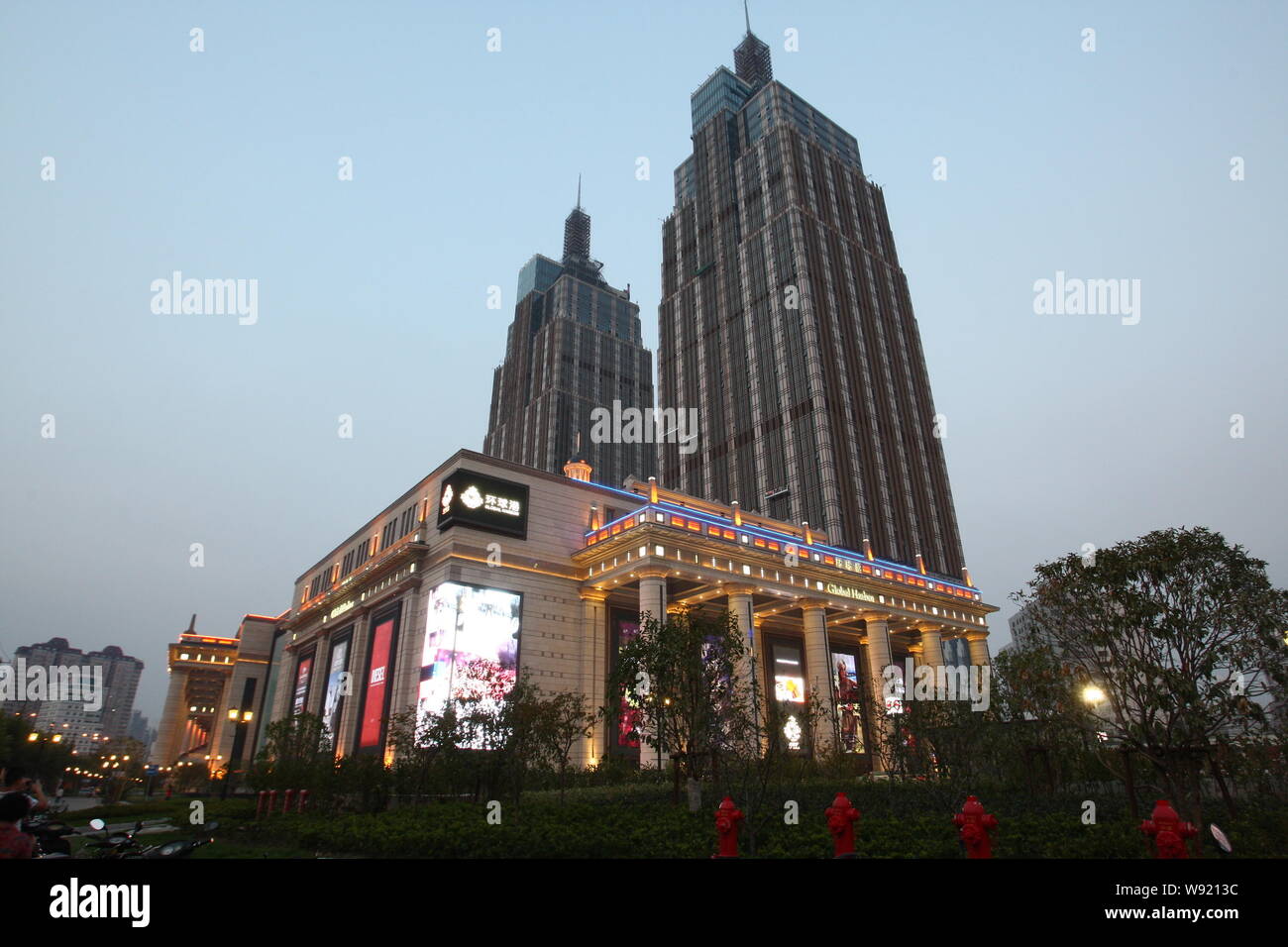Les piétons passer devant le centre commercial du port de Shanghai, Chine, le 9 août 2013. Un nouveau complexe commercial à Shangaï district a dr Banque D'Images