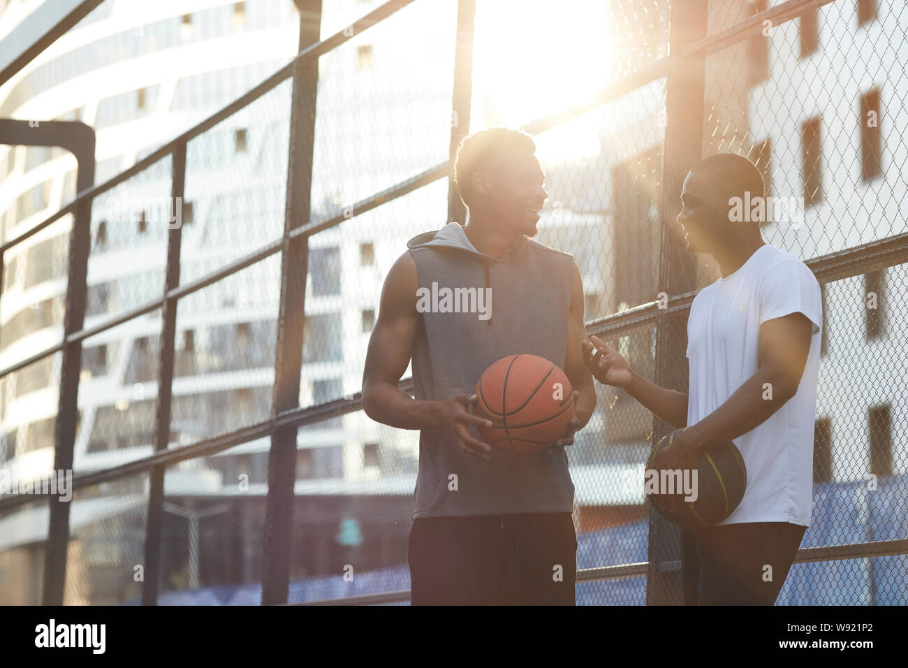 Portrait de deux hommes contemporains africains à discuter tout en se tenant dans la cour de basket-ball en plein air, copy space Banque D'Images