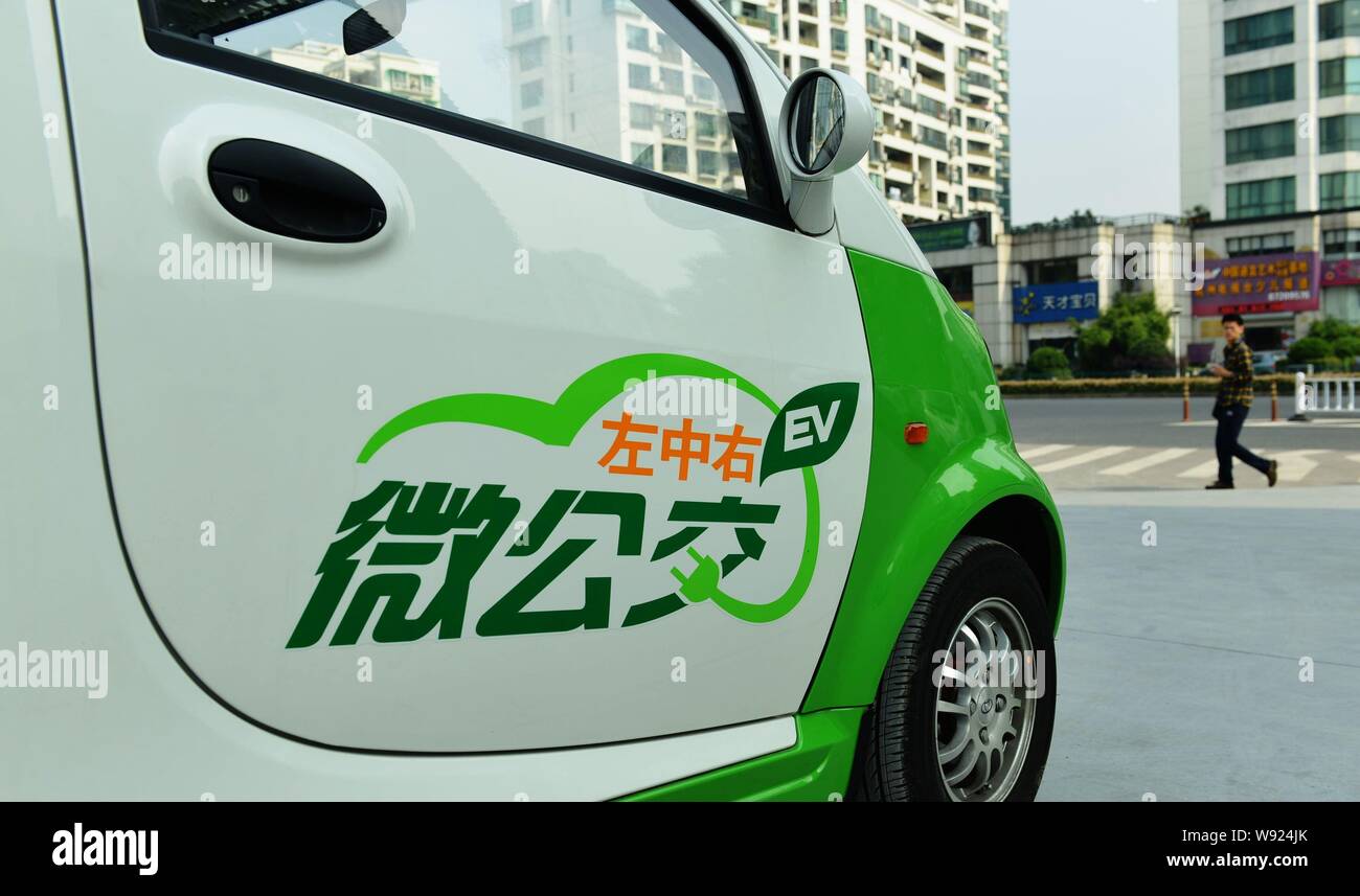 Un piéton marche dernières compact électrique voitures garées à un VE de location de voitures dans la ville de Hangzhou, province de Zhejiang, Chine de l'est le 23 octobre 2013. Le g Banque D'Images