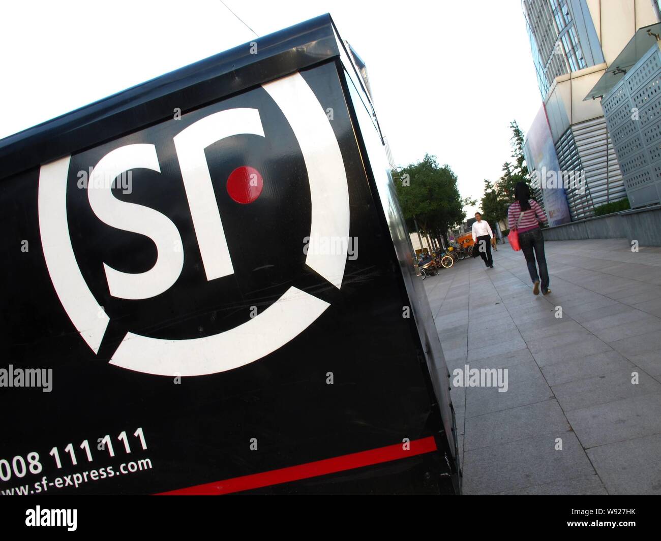 --FILE--piétons passent devant un véhicule de SF Exress dans une rue de Beijing, Chine, 12 septembre 2012. Société de capital chinois Citic Capital Hol Banque D'Images