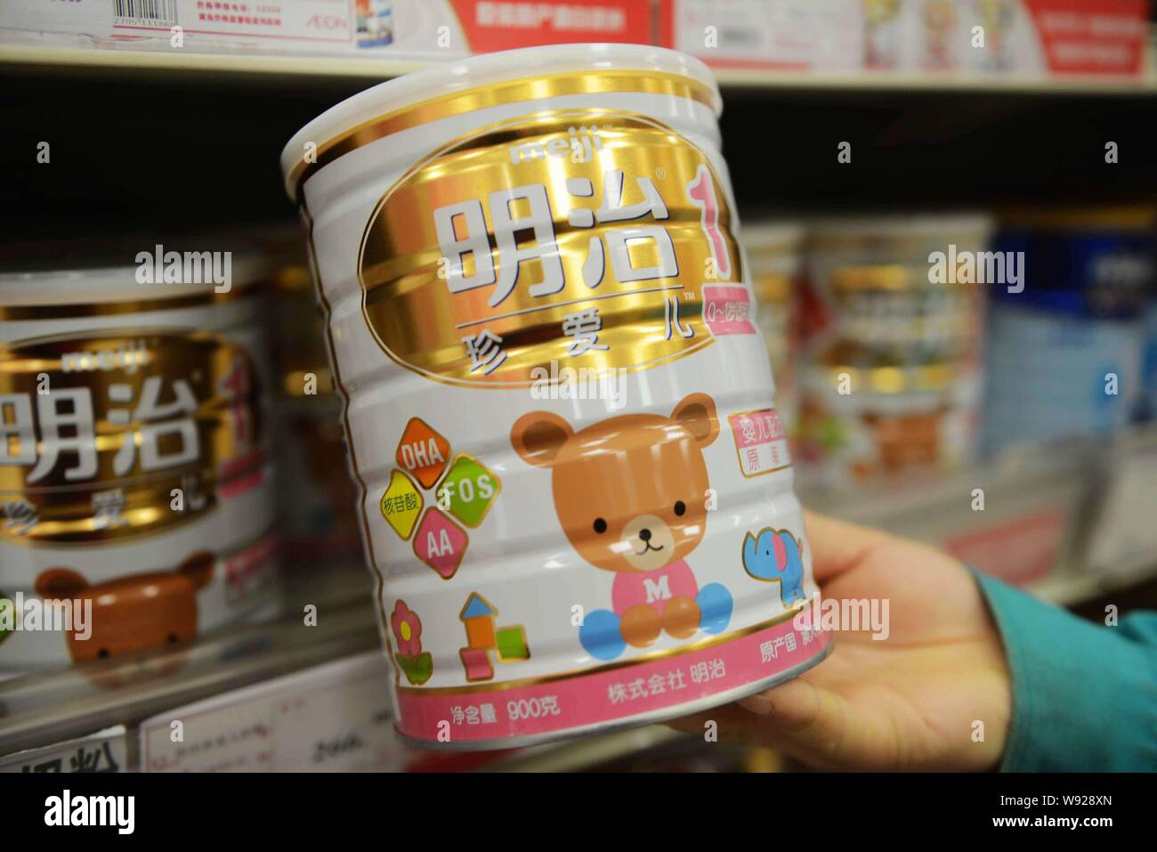 --FILE--qu'un client achète une boîte de lait en poudre pour bébés chéris de Meiji dans un supermarché à Qingdao, Chine de l'est la province de Shandong, 25 février 2013. Ère Meiji Banque D'Images