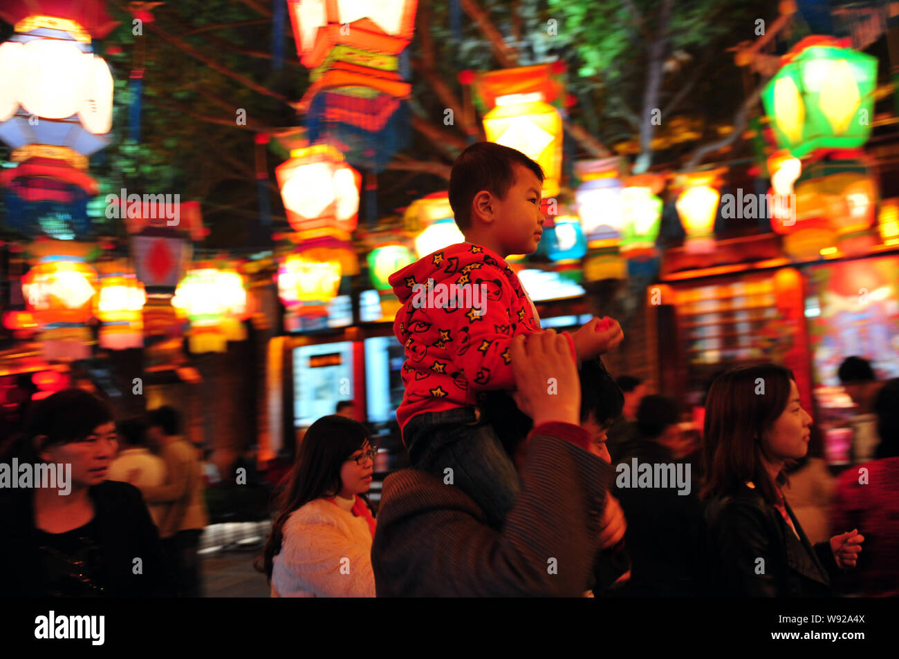 Un père avec son fils sur son épaule lors d'une promenades dans la lanterne juste Splendid China Folk Culture Village dans la ville de Shenzhen, Chine du sud Guangd Banque D'Images
