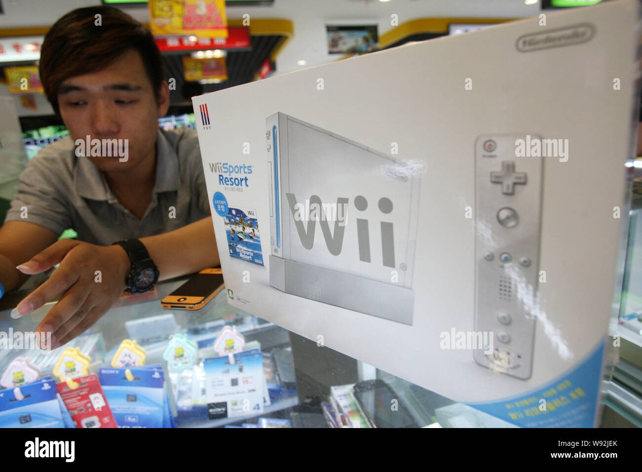Un vendeur vend une console de jeux Nintendo Wii à un étal dans un centre commercial de produits numériques à Shanghai, Chine, le 10 juillet 2013. La Chine devrait bientôt mettre fin à un Banque D'Images