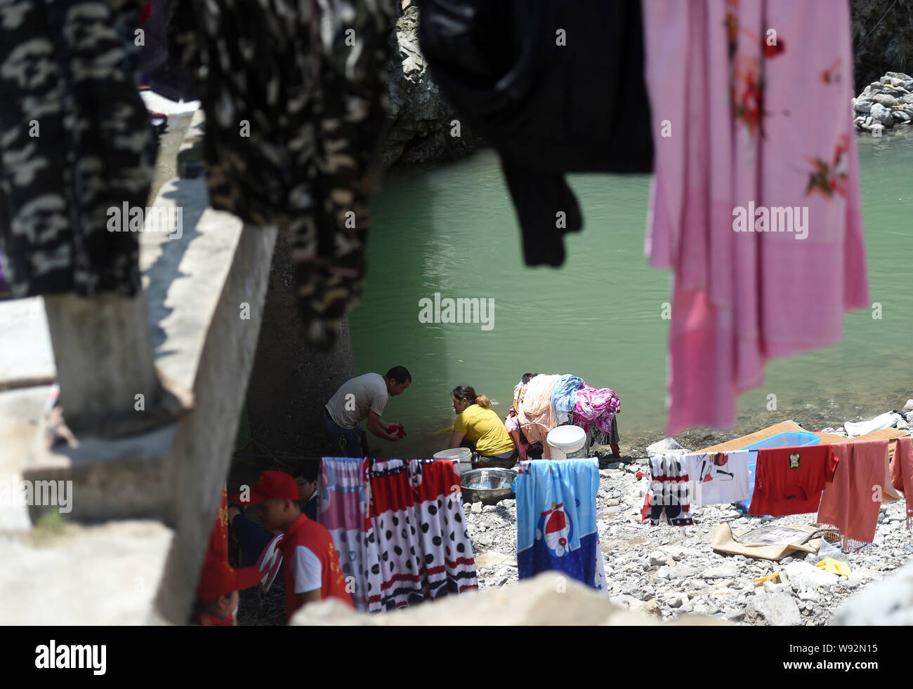 Yongjia, la Province de Zhejiang. Août 12, 2019. Lavez les vêtements des villageois et des feuilles qui ont été trempés par les inondations à côté d'un ruisseau dans Shanzao Village de Yantan Township dans Yongjia County, Zhejiang Province de Chine orientale, le 12 août 2019. Par lundi matin, le nombre de morts dans la province de Zhejiang a augmenté de 39 tandis que les neuf autres sont encore portés disparus, a déclaré que le contrôle des inondations de la province de Zhejiang siège. Le typhon Lekima, le neuvième et le plus puissant typhon de l'année, s'est posé autour de 1:45 h samedi de la ville de Wenling dans la province de Zhejiang. Han Crédit : Chuanhao/Xinhua/Alamy Live News Banque D'Images