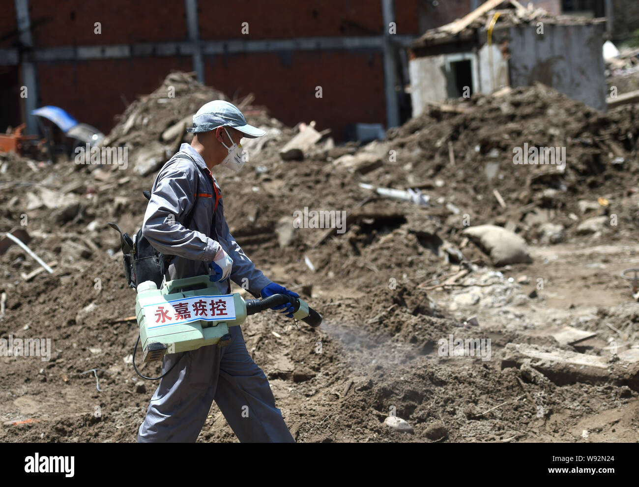 Yongjia, la Province de Zhejiang. Août 12, 2019. Un travailleur stérilise le glissement dans Shanzao site Village de Yantan Township dans Yongjia County, Zhejiang Province de Chine orientale, le 12 août 2019. Par lundi matin, le nombre de morts dans la province de Zhejiang a augmenté de 39 tandis que les neuf autres sont encore portés disparus, a déclaré que le contrôle des inondations de la province de Zhejiang siège. Le typhon Lekima, le neuvième et le plus puissant typhon de l'année, s'est posé autour de 1:45 h samedi de la ville de Wenling dans la province de Zhejiang. Han Crédit : Chuanhao/Xinhua/Alamy Live News Banque D'Images