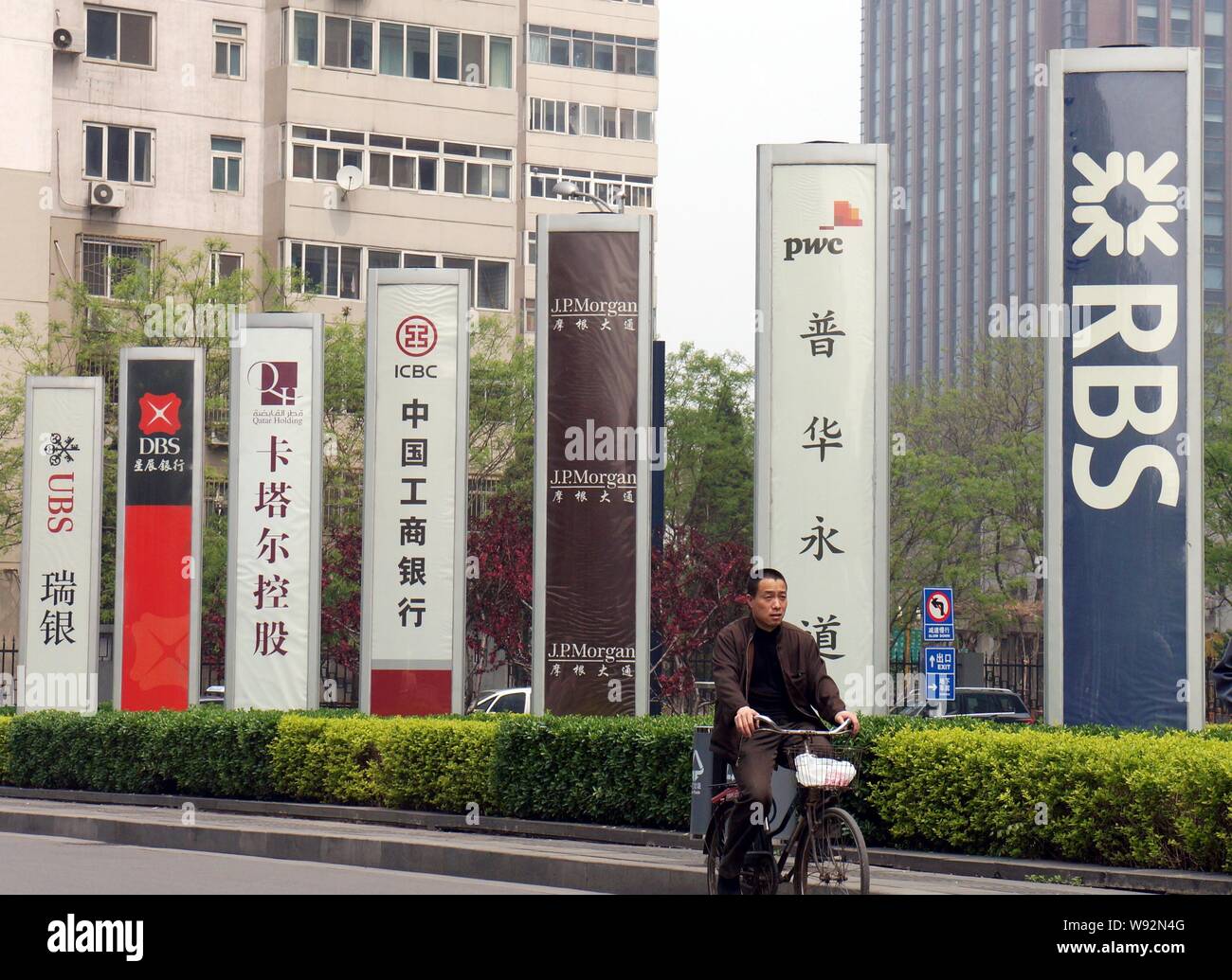 --FILE--un cycliste rides passé une signalisation de Royal Bank of Scotland (RBS), à Beijing, Chine, 22 avril 2012. En raison d'ajustements dans la structure de l'entreprise et Banque D'Images