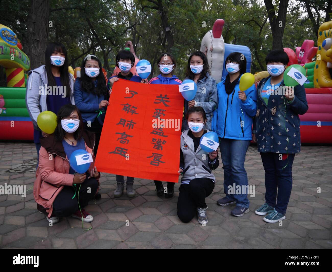 Les bénévoles portent des masques peints avec les lèvres bleues et organiser un travail de calligraphie tout en posant pour des photos de Shanghai, Chine de l'est la province de Shandong, 16 Octobre Banque D'Images