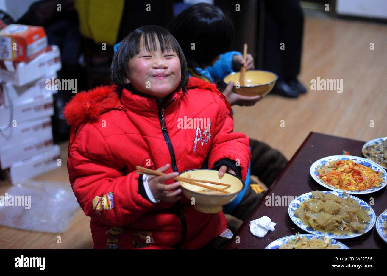 Les jeunes orphelins chinois adopté par Yuan Lihai, le propriétaire d'un orphelinat où 6 enfants ont été tués dans un incendie, prendre un repas à l'Equité de Kaifeng Banque D'Images