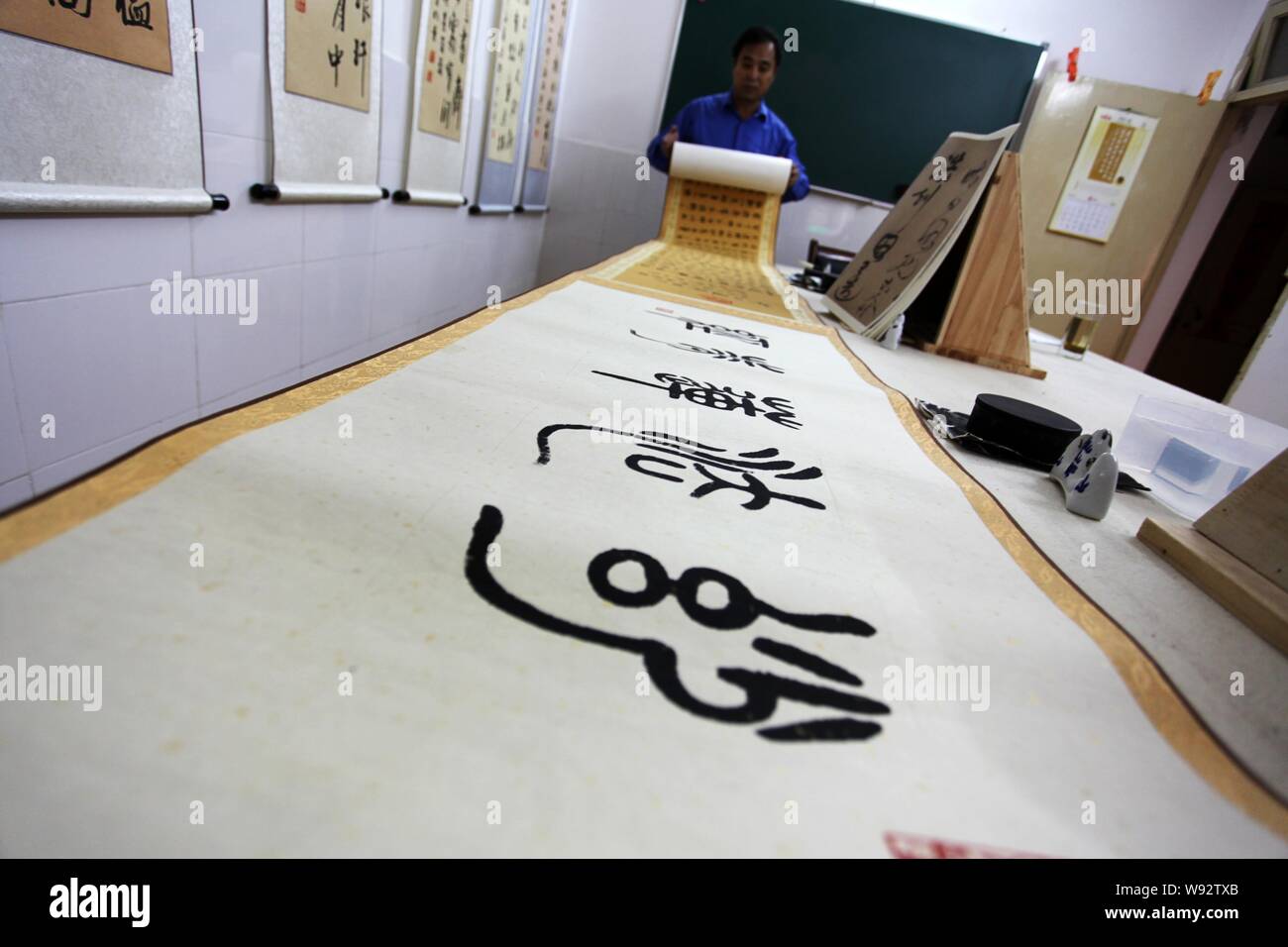 Vous Zhaojing, dont 380,16 m de long de la calligraphie défilement Sutra du Lotus a battu le record du monde, montre un rouleau de calligraphie de Suzhou, en Chine de l'est J Banque D'Images