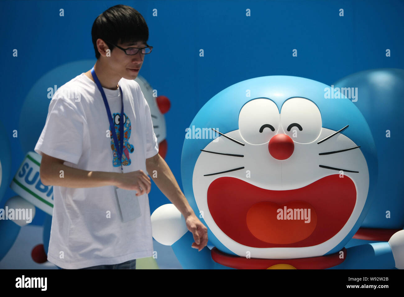 Un employé chinois passe devant un modèle de Doraemon, un célèbre  personnage de dessin animé japonais, lors d'une exposition à Shanghai,  Chine, le 26 avril 2013 Photo Stock - Alamy