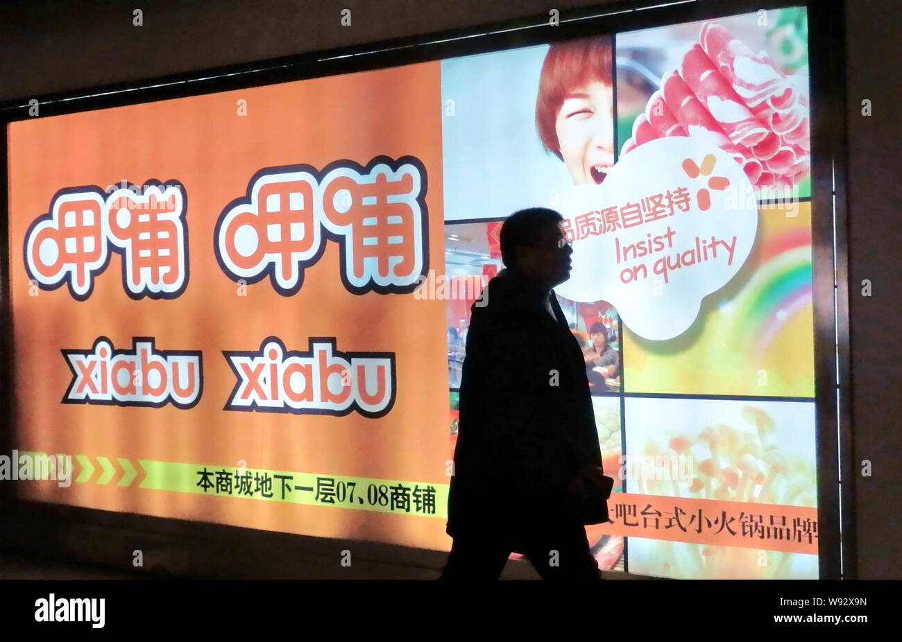 --FILE--un piéton passe devant une publicité de hot-pot Xiabu Xiabu chaîne à Shanghai, Chine, le 28 décembre 2011. Les sociétés de financement par capitaux propres sont Banque D'Images