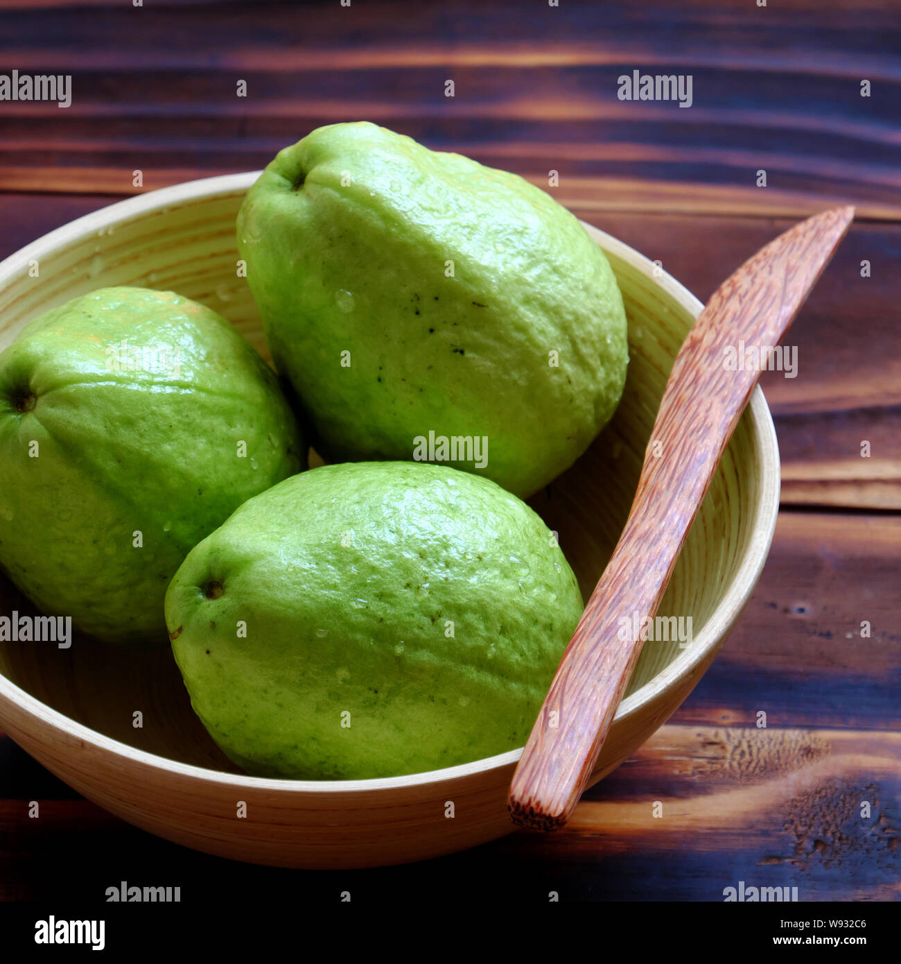 Close up groupe de goyave avec des tranches de fruits sur fond de bois brun,fruits tropicaux riches en fibres, vitamine C et bon marché Banque D'Images