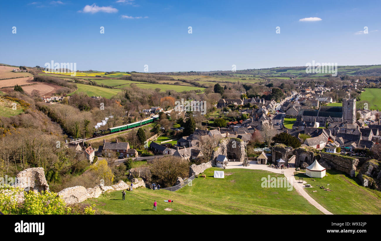 Château de Corfe, England, UK - 27 mars 2019 : un train à vapeur passe sur le village Corfe Castle Fer Swanage dans le Dorset. Banque D'Images
