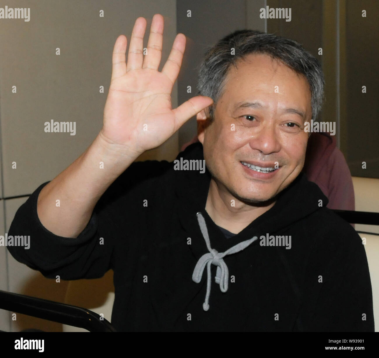 Le réalisateur taïwanais Ang Lee waves après son arrivée à l'Aéroport International de Taiwan Taoyuan à Taipei, Taiwan, 11 novembre 2013. Banque D'Images