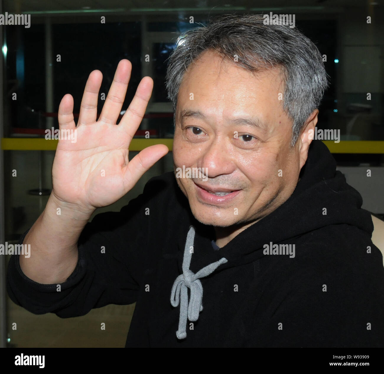 Le réalisateur taïwanais Ang Lee waves après son arrivée à l'Aéroport International de Taiwan Taoyuan à Taipei, Taiwan, 11 novembre 2013. Banque D'Images