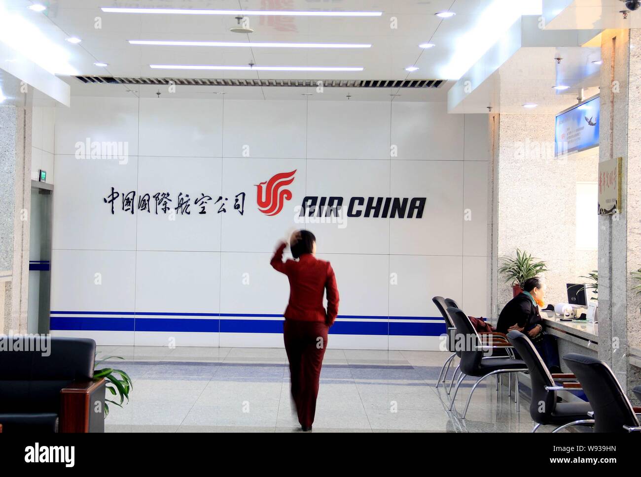 --FILE--un personnel chinois passe devant un panneau d'Air China dans le ticket hall à Beijing, Chine, 22 février 2011. Les compagnies aériennes du continent connu Banque D'Images