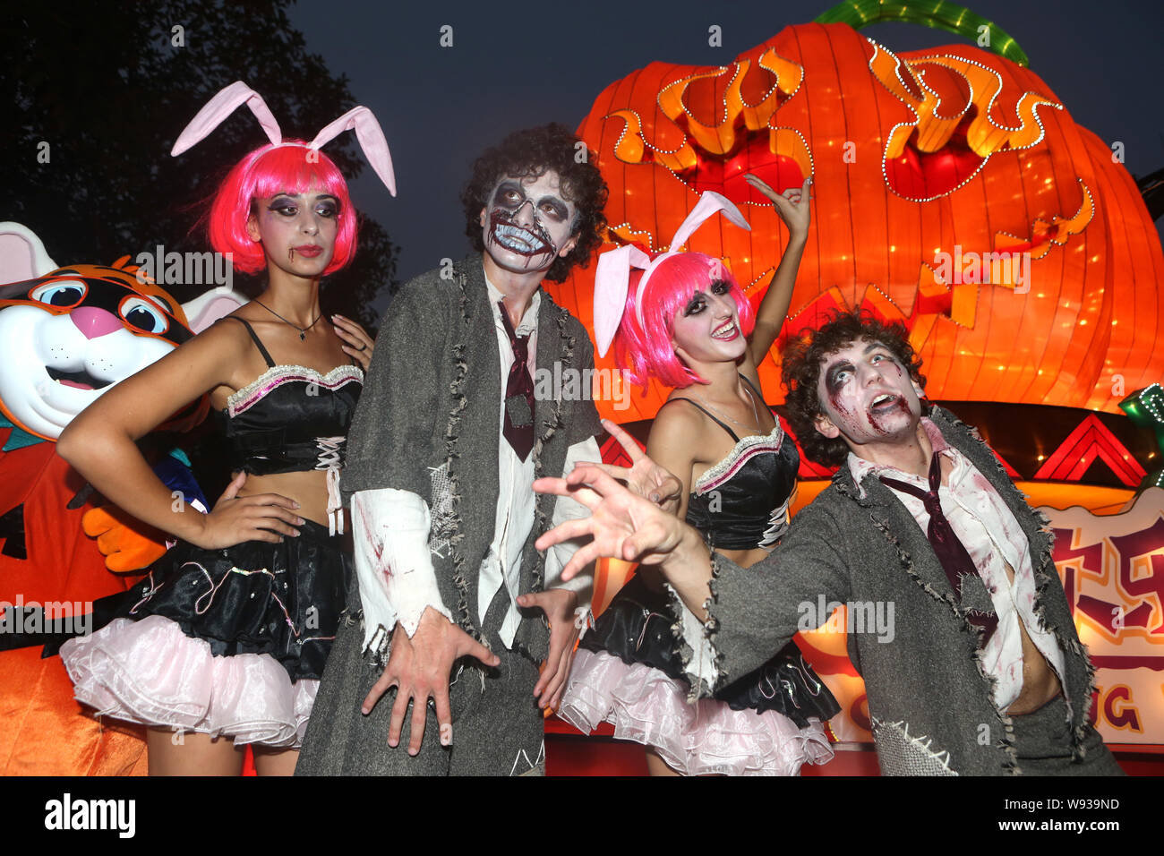 Les artistes vêtus de costumes de zombies posent devant les mondes plus grand jack-o-lantern lors d'une cérémonie de la lumière et une cérémonie de lancement d'une campagne Banque D'Images