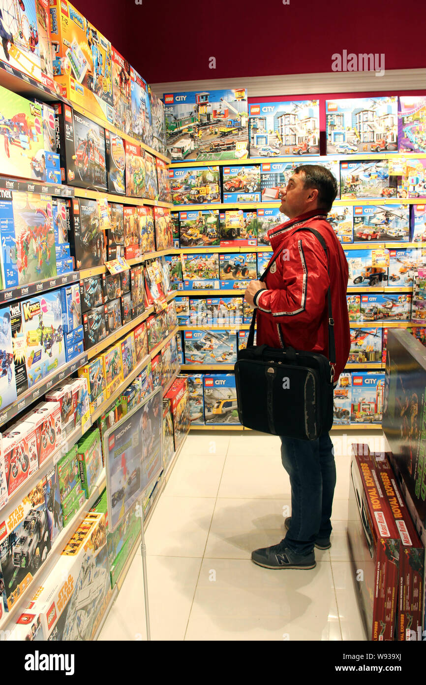 Boutique de jouets. Magasin de jouets. À l'intérieur de magasin de jouets. Lignes d'étagères avec des jouets. La joie des enfants. Man toy entre grande sélection dans la boutique. Boutique pour Banque D'Images