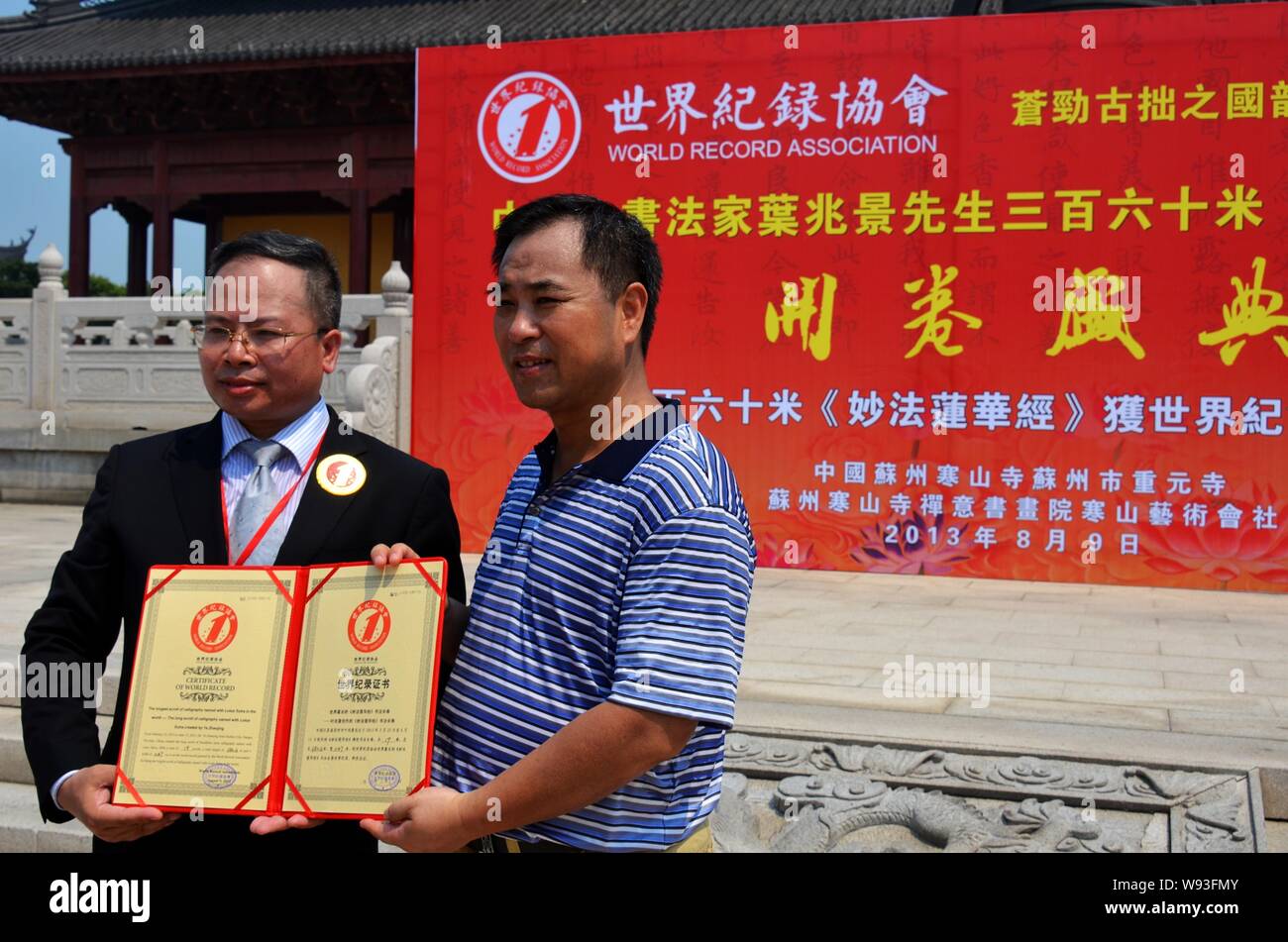 Un officier de l'Association Record du monde délivre le certificat de record du monde à vous Zhaojing, droite, qui a créé un 380,16 mètres de long parchemin de cal Banque D'Images