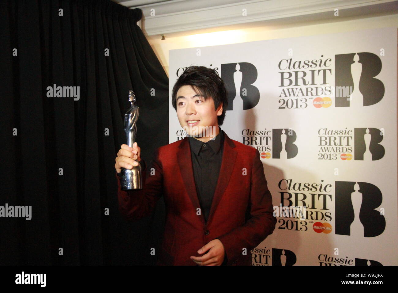 --FILE--pianiste chinois Lang Lang pose avec son trophée après avoir remporté la Classique BRIT Awards au Royal Albert Hall à Londres, Royaume-Uni, le 2 octobre 2013. Banque D'Images