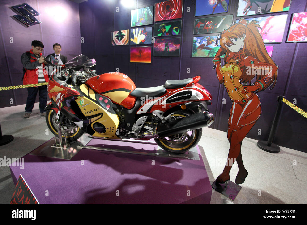 Les visiteurs regarder une moto et une découpe de Asuka Langley Soryu, un personnage de la série animée Neon Genesis Evangelion, dur Banque D'Images