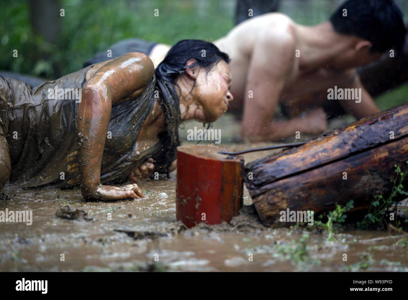 --FILE--stagiaires féminins et masculins de ramper dans la boue lors d'un programme de formation de garde du corps au camp d'initialisation de Gengis Security Academy à Beijing, Chine, 21 A Banque D'Images