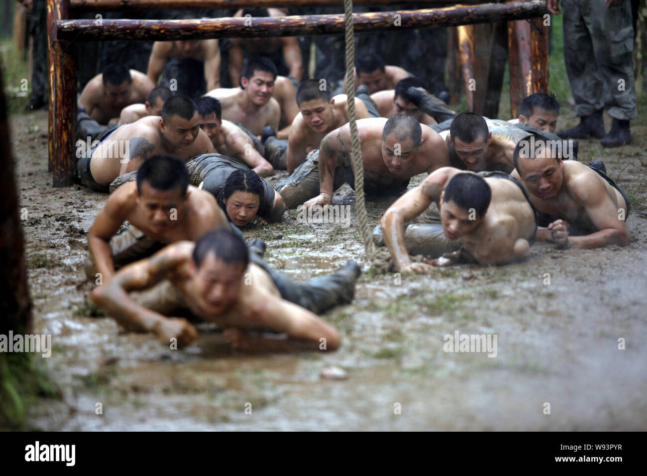 --FILE--stagiaires féminins et masculins de ramper dans la boue lors d'un programme de formation de garde du corps au camp d'initialisation de Gengis Security Academy à Beijing, Chine, 21 A Banque D'Images