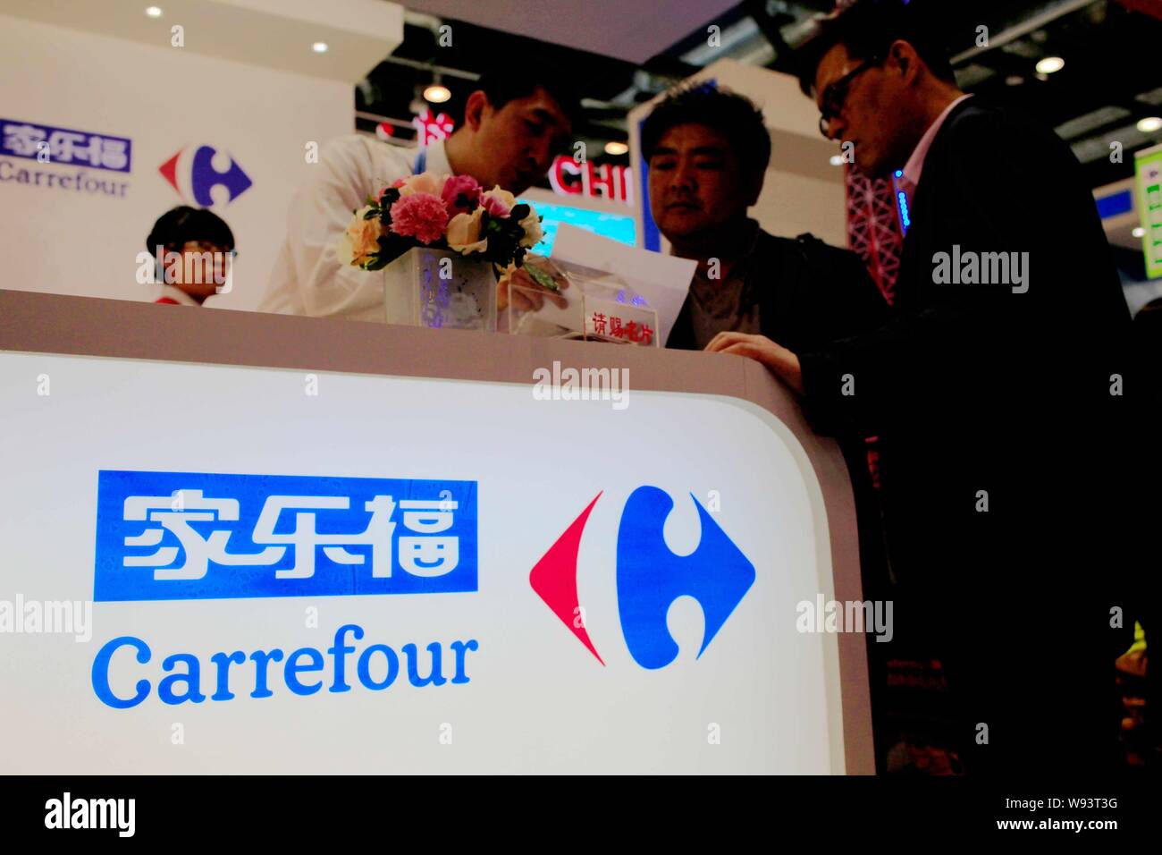 --FILE -- Un employé parle avec les visiteurs au stand de Carrefour lors de la Chine Pékin 2013 Salon International du Commerce des services (CIFTIS) en B Banque D'Images