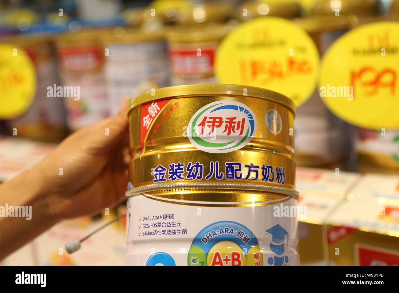 --FILE--un client des magasins pour une boîte de lait en poudre de Yili dans un supermarché dans la région de Xuchang, province de Henan, Chine centrale 19 septembre 2013. Une répression o Banque D'Images