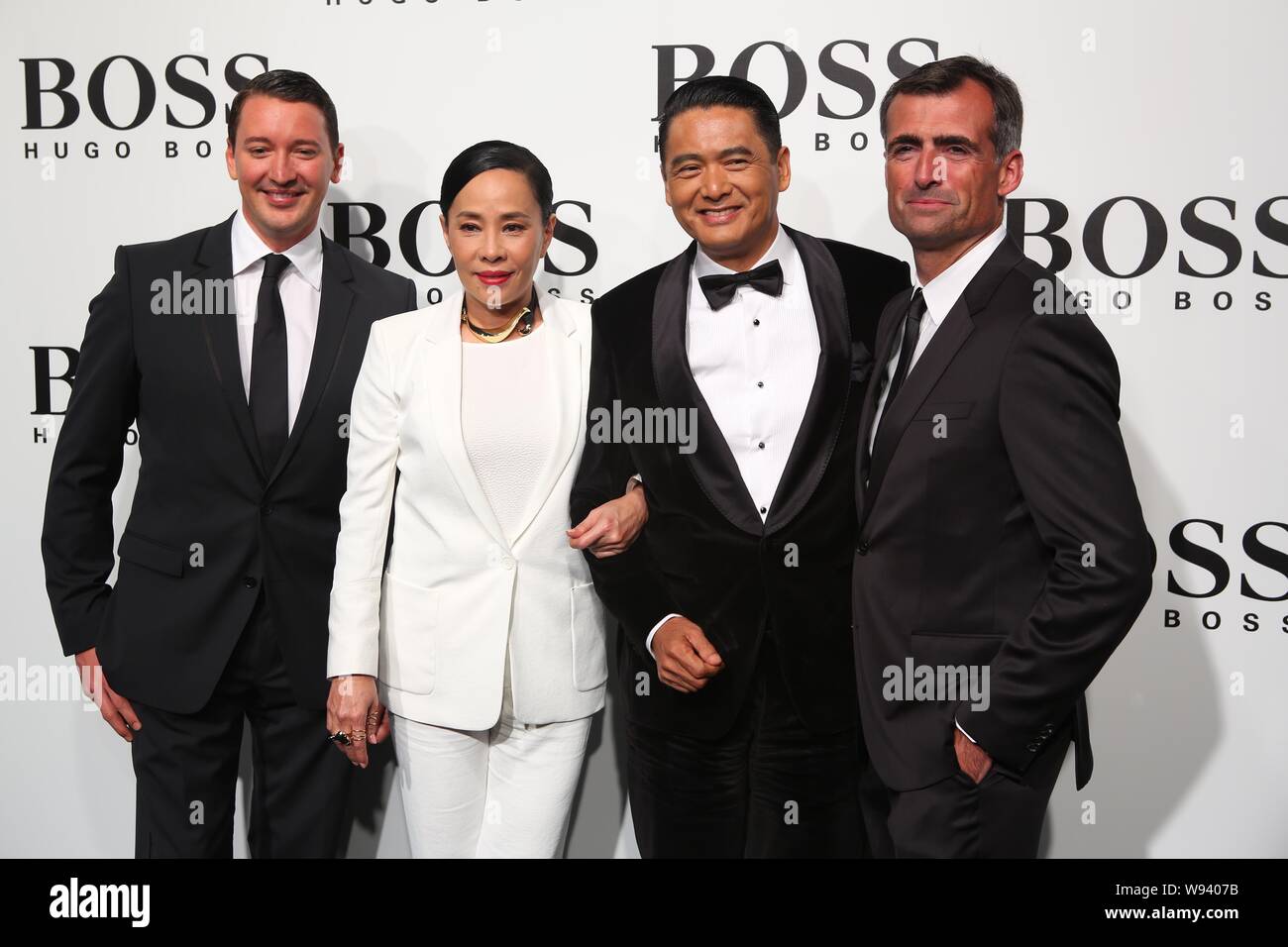 Hong Kong l'acteur Chow Yun-fat, deuxième à droite, et son épouse Jasmine Tan, deuxième à gauche, posent avec Hugo Boss supérieurs qu'ils arrivent pour un défilé de Banque D'Images