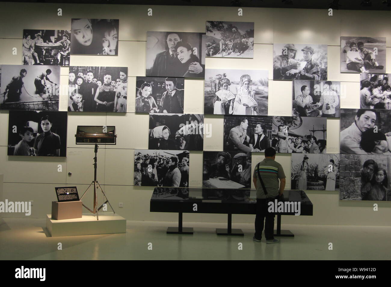 Un visiteur regarde des photos noir et blanc des vieux films chinois au Musée du Film de Shanghai à Shanghai, Chine, le 17 juin 2013. Le Shanghai Film Muse Banque D'Images