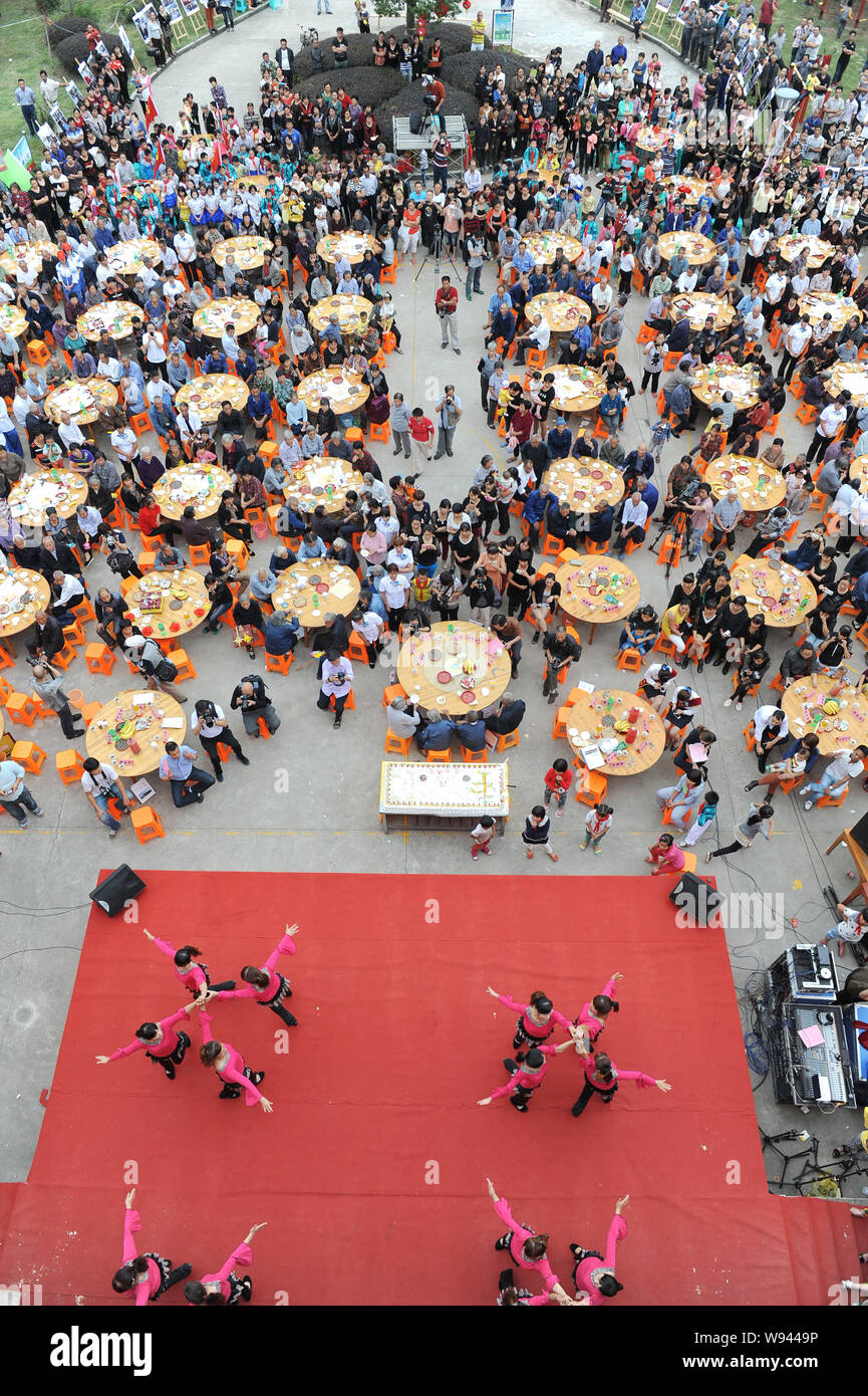 Les personnes âgées locales manger des gâteaux et d'autres aliments autour de tables à la célébration de l'anniversaire dans Dongxidan collective village, ville de Dongcheng, ville de Linhai, ea Banque D'Images