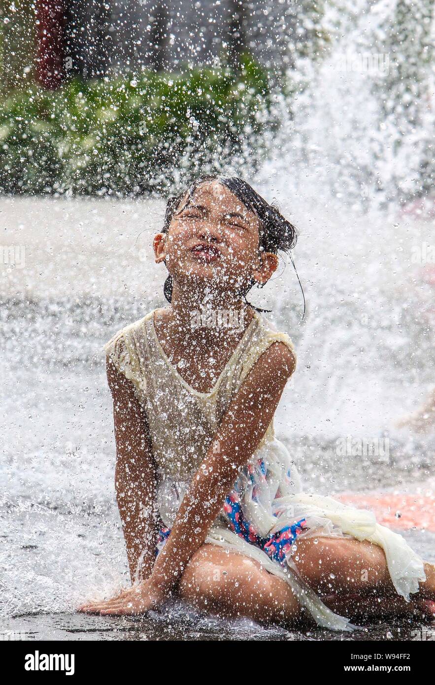 Une jeune chinoise joue à la Fontaine pour son corps mouillé parce que de la haute température à Foshan, province du Guangdong, Chine du sud-est 2 juin 2013. Le HIG Banque D'Images