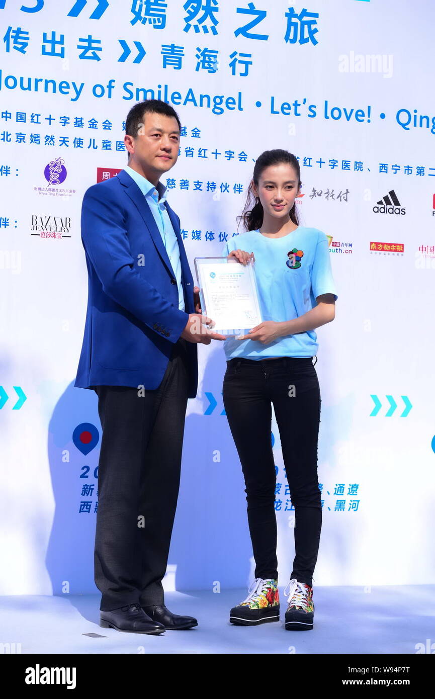 L'acteur chinois Li Yapeng, à gauche, et l'actrice de Hong Kong Angelababy détient un certificat au cours d'un évènement promotionnel pour le sourire Angel Foundation à Pékin Banque D'Images