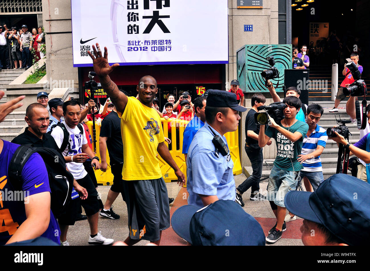 NBA superstar Kobe Bryant vagues pour les fans dans une rue piétonne sur son chemin à un événement pour rencontrer les fans lors de sa tournée en Chine à Wuhan, Chine centrale Banque D'Images