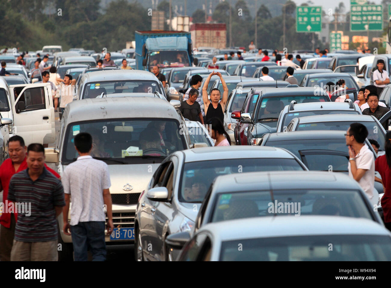 Les touristes chinois reste à côté de leur voiture alors qu'ils attendent dans une longue file d'attente dans un embouteillage sur une autoroute au cours de la fête de la Mi-automne et Banque D'Images