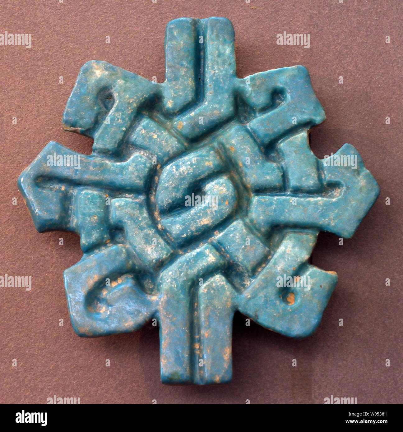 Élément de décoration (lettres lam-alif) 13ème -14ème siècle. L'Iran, l'écriture arabe est utilisé pour noter plusieurs langues, principalement l'arabe, persan, turc et urdu. . Parfois, des lettres traitées comme des motifs décoratifs sont méconnaissables. Plusieurs objets montrent les mêmes mots (bismillah : 'au nom de Dieu, le Clément, le Miséricordieux") écrit dans des styles différents. Cette formule ouvre 113 des 114 sourates du Coran. Banque D'Images