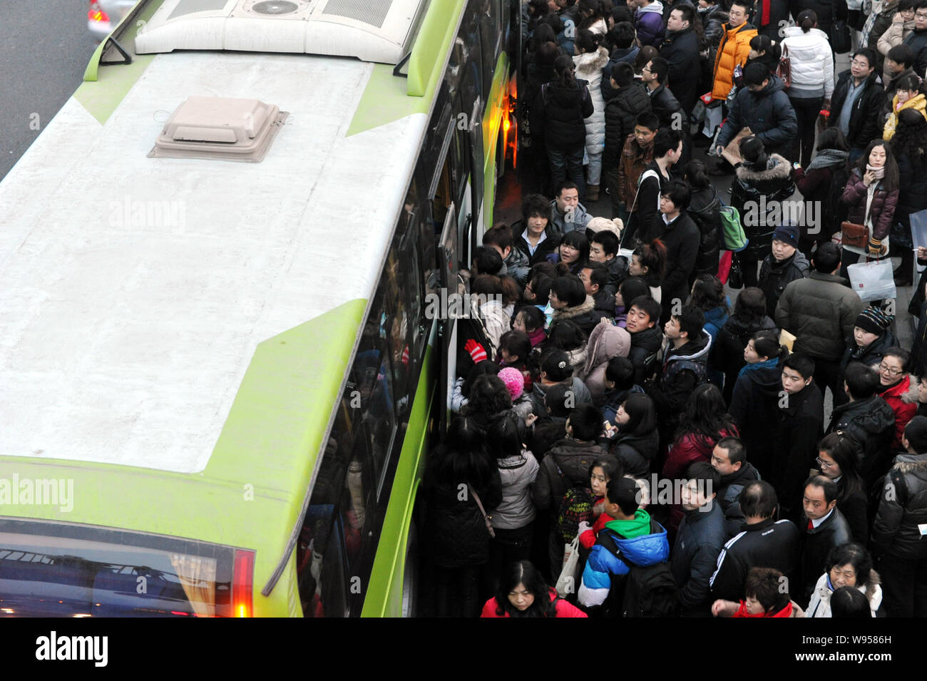 --FILE--une foule de passagers essaient de confiture dans un autobus à Beijing, Chine, 18 février 2011. Chines population urbaine a dépassé le nombre de personnes livi Banque D'Images